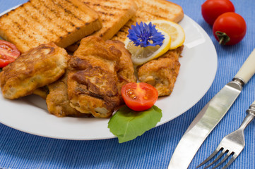 Fish in batter with croutons grilled. Wooden background. Top view. Close-up