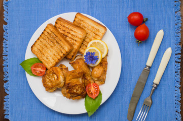 Fish in batter with croutons grilled. Wooden background. Top view. Close-up