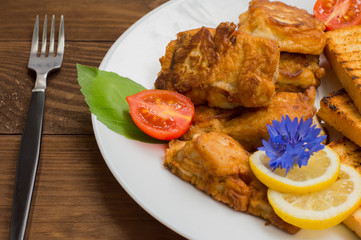 Fish in batter with croutons grilled. Wooden background. Top view. Close-up