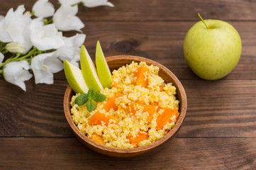 Wheat cereals with pumpkin and apples. Wooden rustic background. Close-up