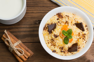 Wheat cereals with pumpkin and chocolate. Wooden rustic background. Close-up. Top view