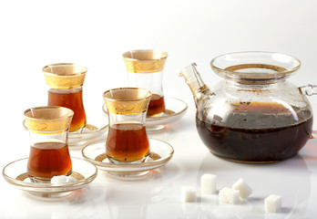 черный чай в заварочном чайнике и в стаканах