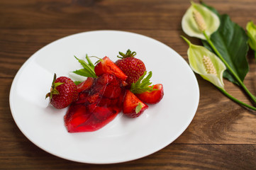 Jelly with strawberries. On a wooden rustic background. Close-up. Top view