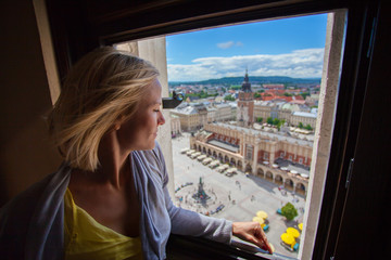 Fototapeta Female traveler standing on the tower of the church of St. Mary and looks to the Main Market Square in Krakow. Poland obraz
