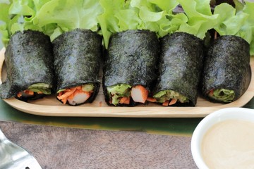 Fresh vegetable salad roll with seaweed and dressing.