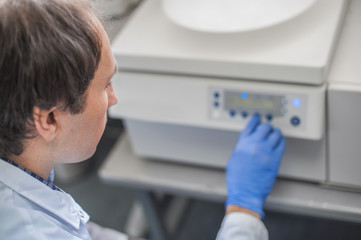 Obraz premium Technician uses the centrifuge machine