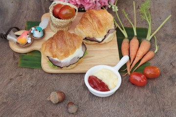 Croissant sandwich with grill pork, vegetable and cheese.