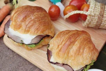 Croissant sandwich with grill pork, vegetable and cheese.