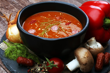 beef stew or goulash in old pan served with spoon and napkin on rustic wooden background