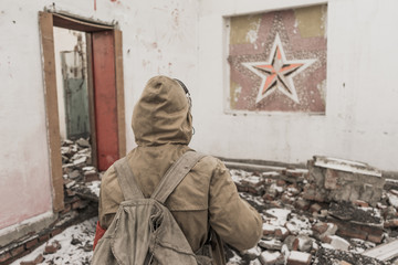 Fototapeta premium young boy stands near the destroyed building