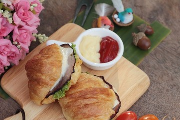 Croissant sandwich with grill pork, vegetable and cheese.