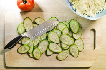 knife and sliced vegetables on a wooden board