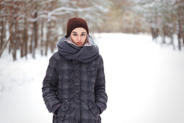 Fototapeta na wymiar girl in the winter woods on a snowy road