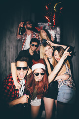 Group of friends entering the club and having fun. New year's party  - obrazy, fototapety, plakaty