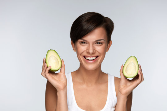 Beautiful Smiling Woman With Green Avocado Halves In Hands. Diet