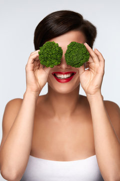 Food For Health. Beautiful Woman Holding Broccoli Before Eyes