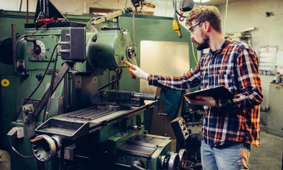 Young mechanic checks the machine