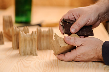 Carpenter hands polishing wood with sandpaper - obrazy, fototapety, plakaty