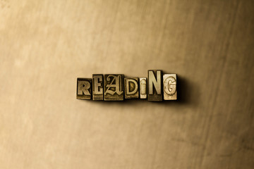 READING - close-up of grungy vintage typeset word on metal backdrop. Royalty free stock - 3D rendered stock image.  Can be used for online banner ads and direct mail.