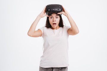 Shocked young lady wearing virtual reality device