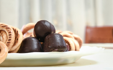 chocolates and cookies on a plate, on white