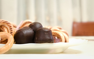 chocolates and cookies on a plate, on white
