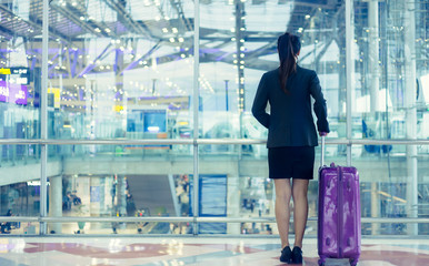 Female walking through the airport using her smartphone device.