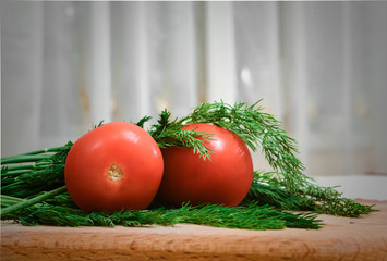 fresh tomatoes and greens on a wooden table