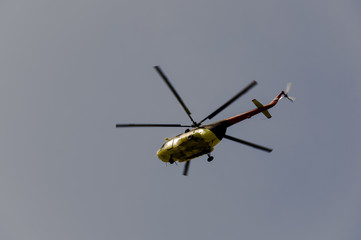 Fototapeta na wymiar Helicopter is flying in the blue sky