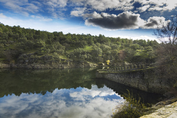 Fototapeta premium Riverbank and partial fortress wall of Bruitrago de Lozoya, Spain, Madrid.
