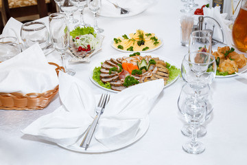 Cutlery and cold cuts served on a festive table in restaurant