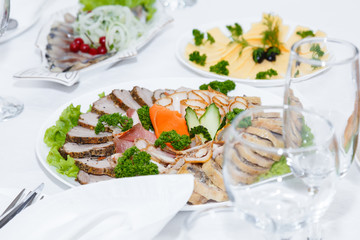 Cutlery and cold cuts served on a festive table in restaurant