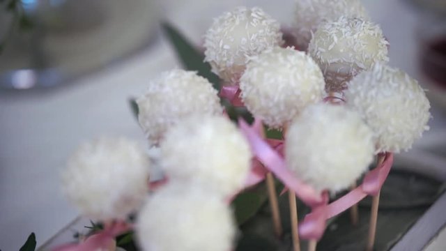 Serving of wedding table. Candy coconut flakes on a skewer at the wedding table close up