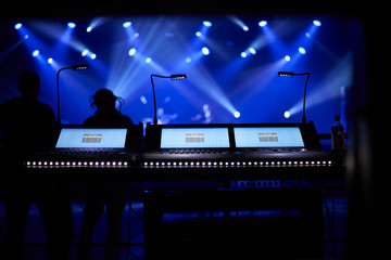 sound mixer console with concert background under blue floodlights. Copy space for advertising text.
