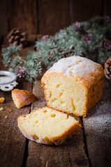 freshly baked cake with icing sugar on wooden background with fir trees branch. Christmas mood. Selective focus