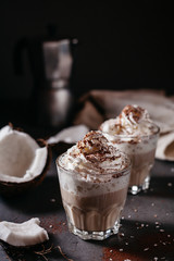 Coconut latte on a concrete table. Broken coconut. Low key food photo.