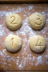 Four equal portions of dough on wood