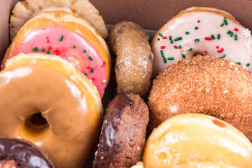 An assorted dozen donuts in a box isolated on a white background