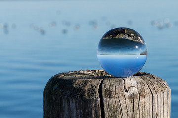Verkehrte Welt, Glaskugel auf Holzpfahl