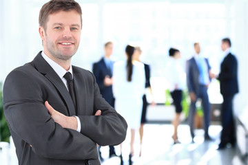 Happy mature business man looking at camera with satisfaction at office