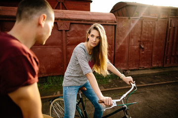 Fototapeta na wymiar Couple on bikes.Young beautiful woman on bike looking at boyfriend. Love on bikes.