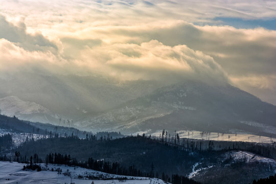 heavy clouds over mountains in snow