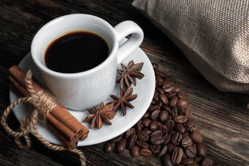 Coffee composition with black coffee, cinnamon on the old wooden