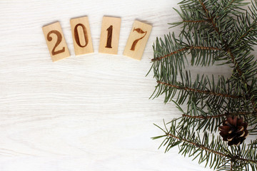  new year 2017/ real green tree branch with pine cones and wooden signs of numbers top view 