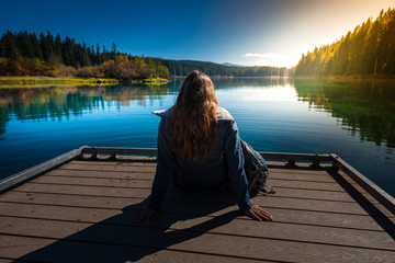 Fototapeta premium Hiker resting on a deck by the Clear Lake Oregon