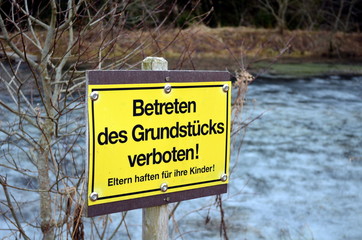 Verbotsschild vor zugefrorenem Teich