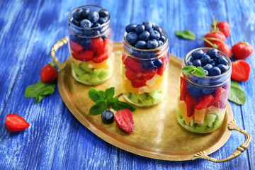 Glass jars with fruits and on metal tray