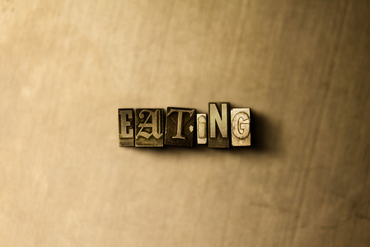 EATING - close-up of grungy vintage typeset word on metal backdrop. Royalty free stock - 3D rendered stock image.  Can be used for online banner ads and direct mail.