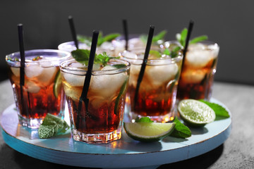 Glasses of cocktail with ice on dark background