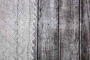 Fototapeta premium Delicate crocheted woolen downy material over rustic wooden background